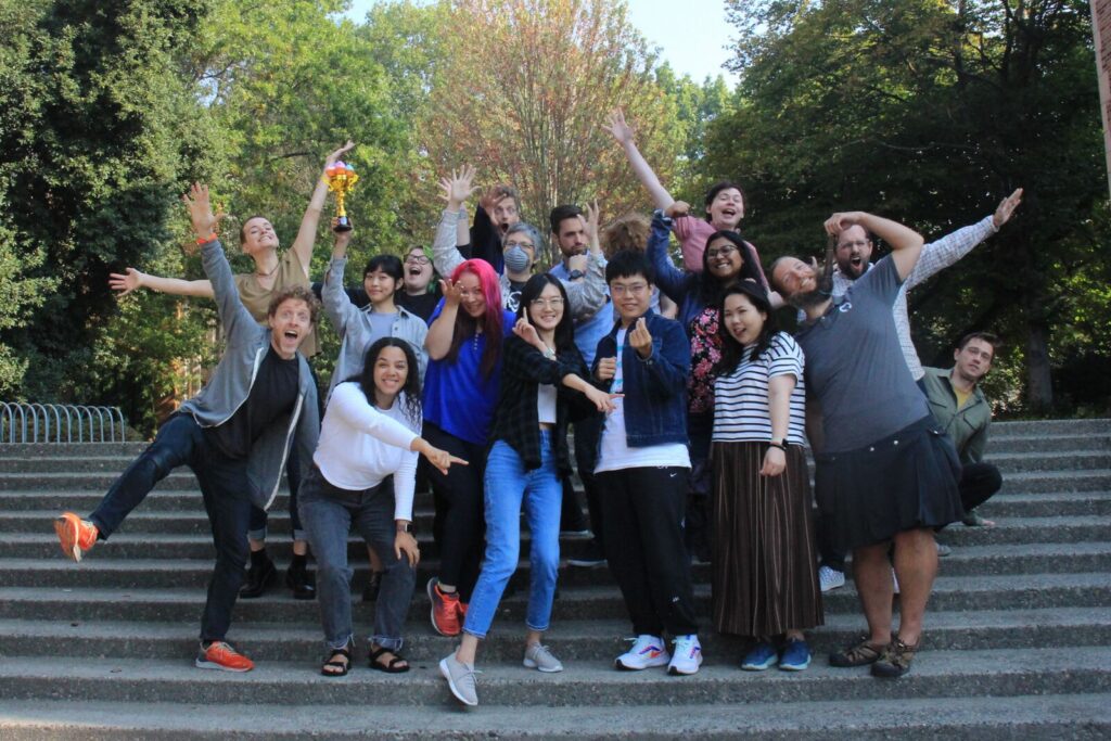 A photo of the CDSC group on some steps with their hands in the air. There are nineteen people in the photo. NINETEEN!