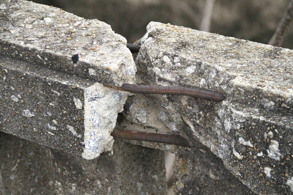 A span of cracked concrete with exposed rebar.